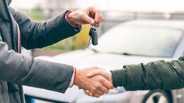 person handing over keys for car finance